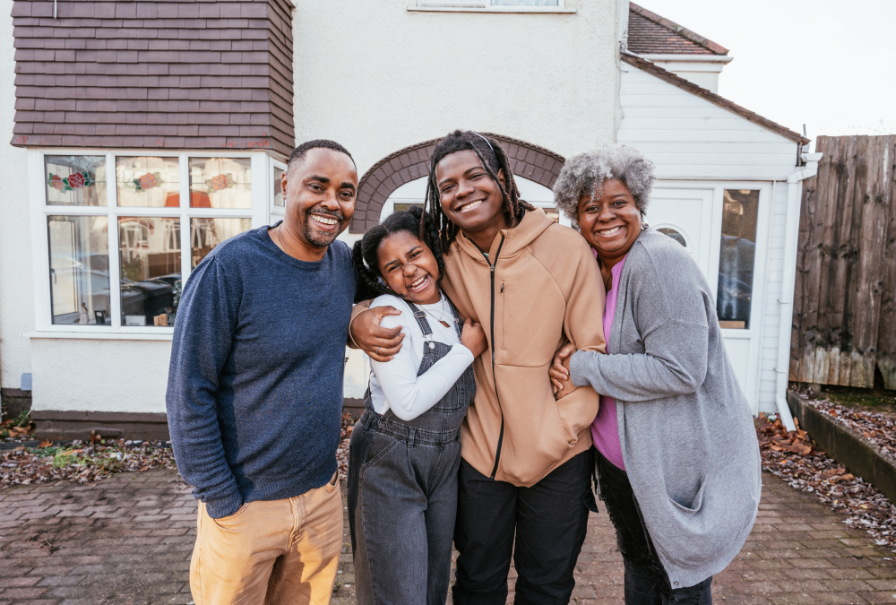 Happy family posing outside their home.