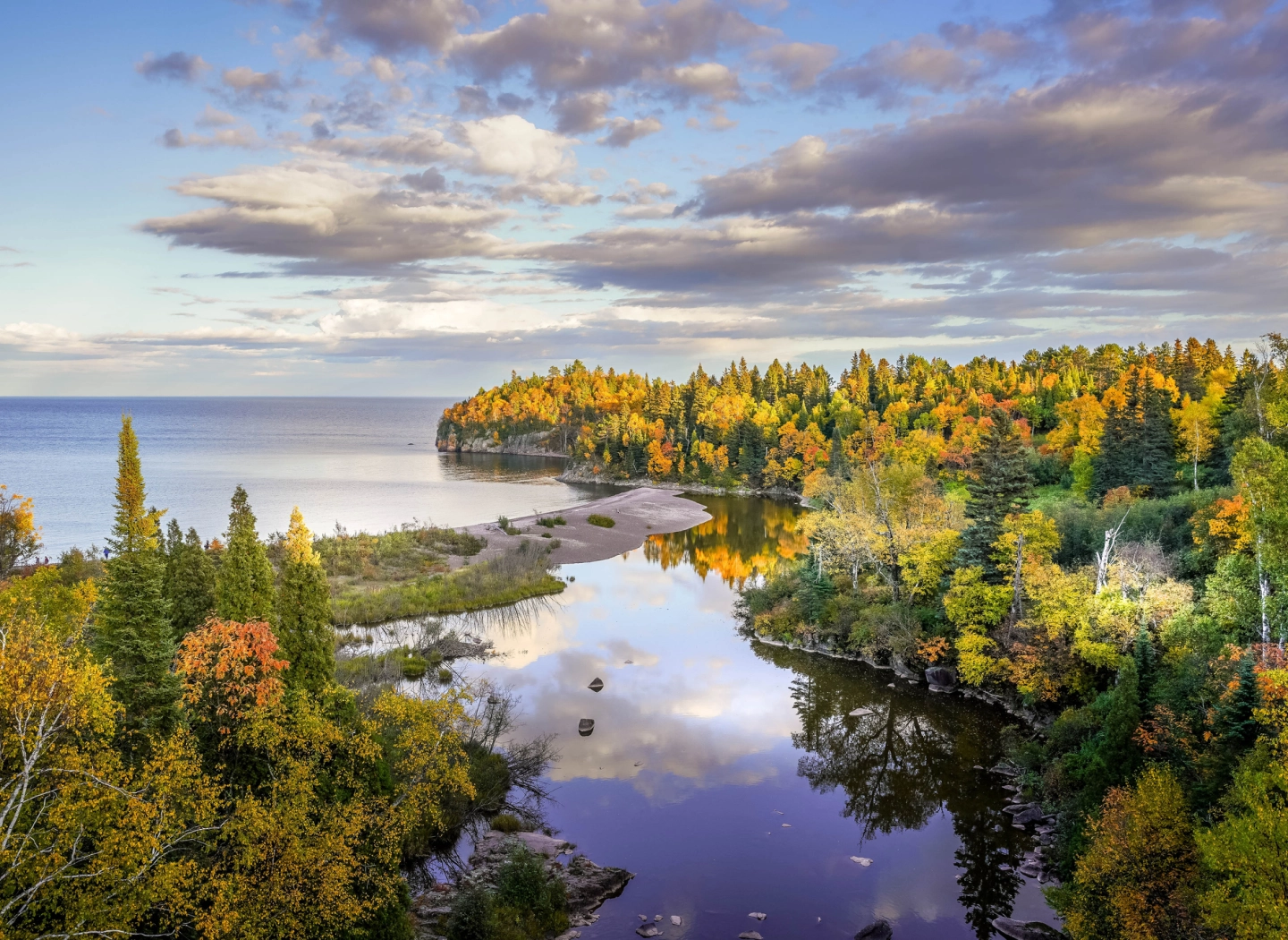 Autumn forest by a calm reflective lake.